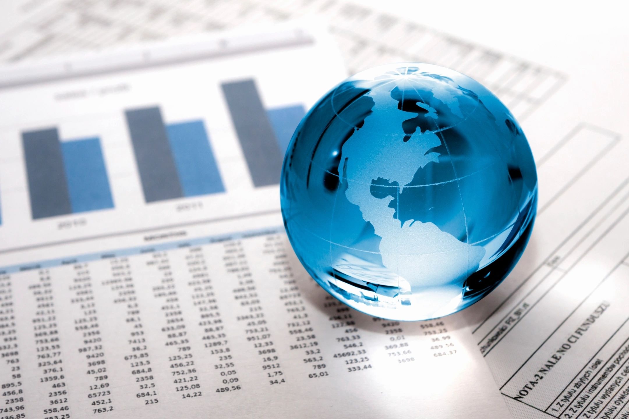 Glass globe on financial documents representing global business